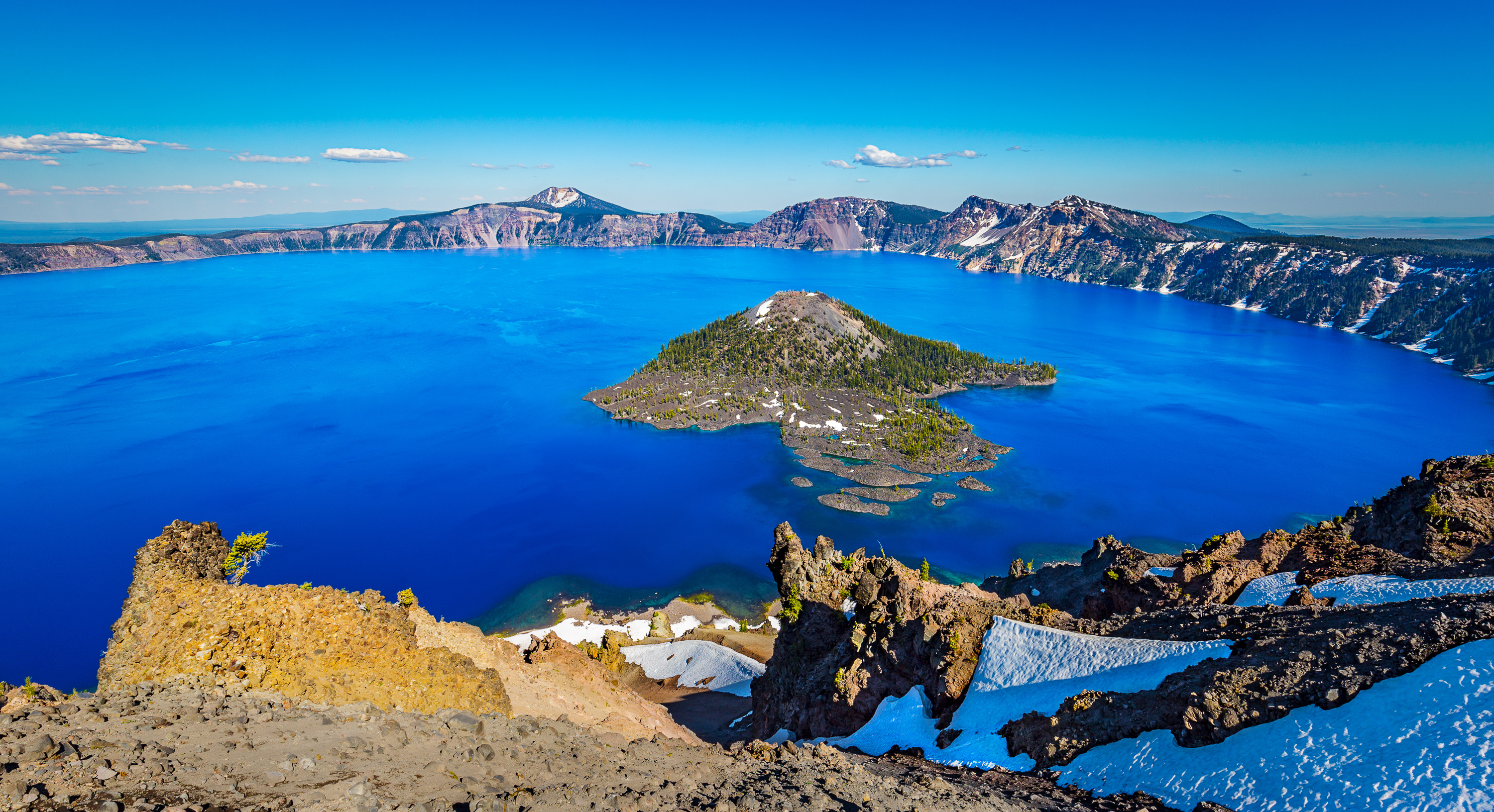 When it first comes into view, the color of Crater Lake simply takes anyone's breath away. It is so saturated blue that he/she must pinch himself/herself to realize that it isn't fake. It is real. But, how can it be so blue? Pure water of the deepest lake in the US basically absorbs all the colors of spectrum. In other words, only the blue wavelengths bounce back out.